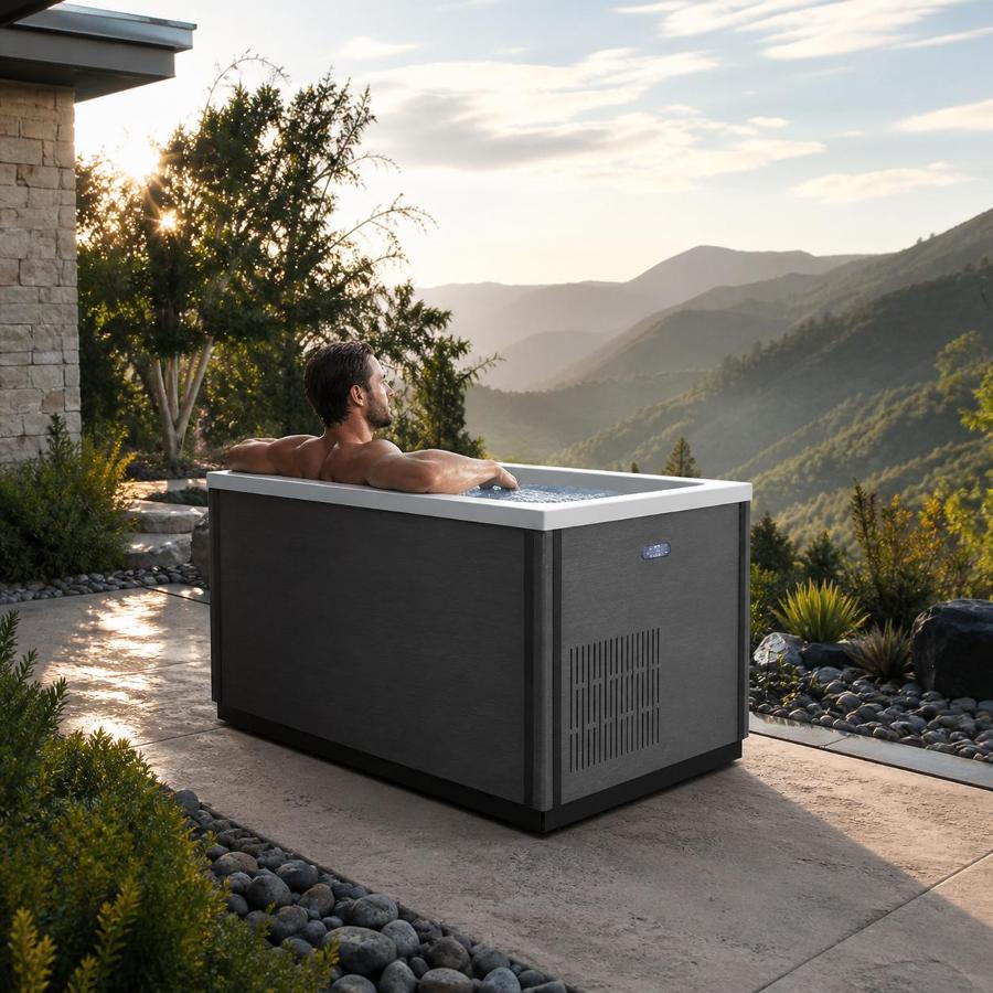 Outdoor cold plunge tub installed on a patio deck at twilight near a modern home